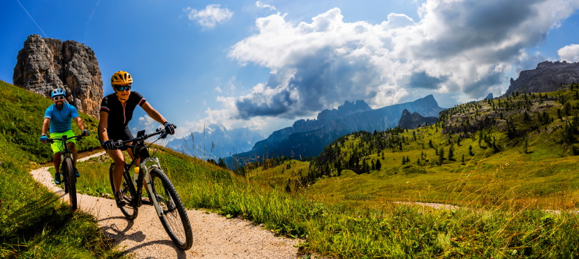Cycling on bikes in Dolomites mountains.